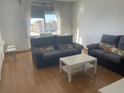 a living room with a couch and a coffee table at Piso coqueto Chiclana in Chiclana de la Frontera