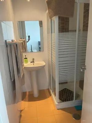 a white bathroom with a sink and a shower at Piso coqueto Chiclana in Chiclana de la Frontera