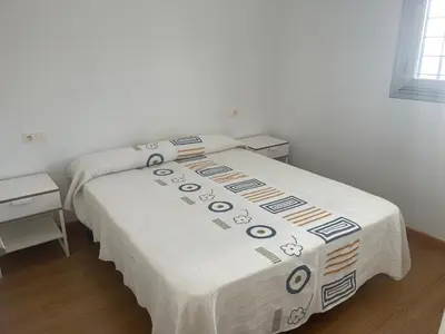 a bedroom with a bed with a blanket on it at Piso coqueto Chiclana in Chiclana de la Frontera
