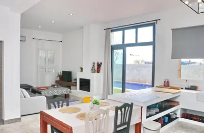 a kitchen and living room with a table and chairs at Casa Aqua in El Guijo