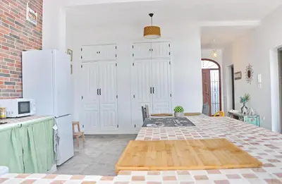 a kitchen with white cabinets and a large bed at Casa Aqua in El Guijo