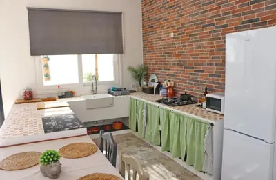 a kitchen with a brick wall and a kitchen with tables at Casa Aqua in El Guijo