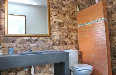 a brick bathroom with a sink and a toilet at Casa Aqua in El Guijo