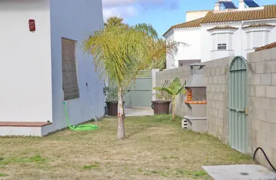 a small palm tree in a yard next to a house at Casa Aqua in El Guijo