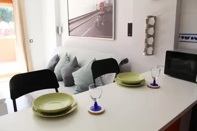 a table with two green plates and glasses on it at Novo Sancti Petri, con piscina todo el año, La Mariposa by Chiclana Dreams in Chiclana de la Frontera