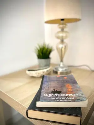 a book sitting on top of a table with a lamp at MyChoice Ático de Luna in Rota