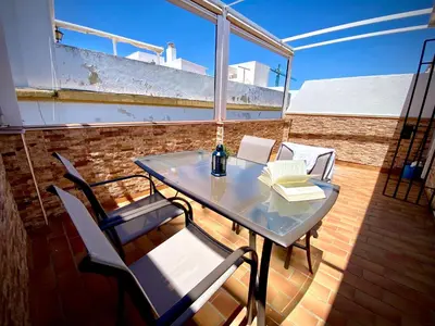 a glass table and chairs on a balcony at MyChoice Ático de Luna in Rota
