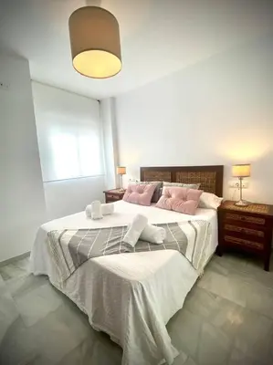 a bedroom with a large bed with pink pillows at MyChoice Ático de Luna in Rota