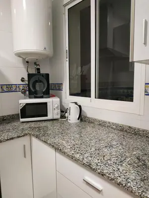a kitchen with a microwave and a counter top at Apartamento Las Canastas Cádiz Centro a pie de Catedral y playa in Cádiz