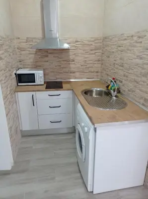 a small kitchen with a sink and a microwave at Apartamento Cerrofuerte in Jerez de la Frontera