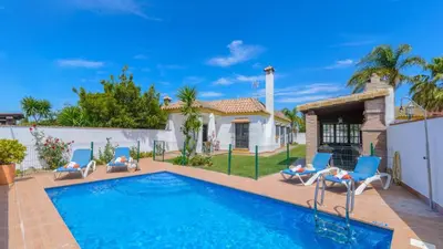 a swimming pool with chairs and a house at Villanueva - Casa 2 Conil Frontera by Ruralidays in Conil de la Frontera