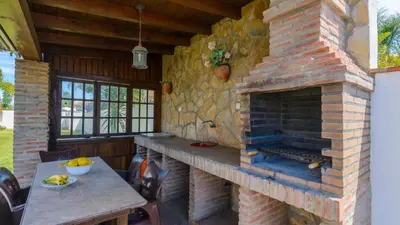 a stone fireplace in a kitchen with a table at Villanueva - Casa 2 Conil Frontera by Ruralidays in Conil de la Frontera