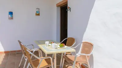 a table with chairs and a plate of fruit on it at Villanueva - Casa 2 Conil Frontera by Ruralidays in Conil de la Frontera