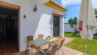 a patio with a table and an umbrella at Villanueva - Casa 2 Conil Frontera by Ruralidays in Conil de la Frontera