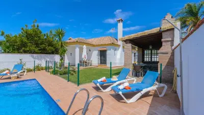 a swimming pool with two lounge chairs and a house at Villanueva - Casa 2 Conil Frontera by Ruralidays in Conil de la Frontera