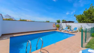 a swimming pool with blue water in a backyard at Villanueva - Casa 2 Conil Frontera by Ruralidays in Conil de la Frontera