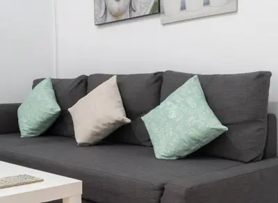 a gray couch with four pillows on it at Apartoyou - Centro Histórico in El Puerto de Santa María