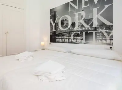 a white bed with two white towels on it at Apartoyou - Centro Histórico in El Puerto de Santa María