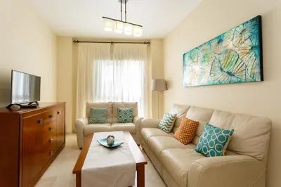 a living room with a couch and a table at Apartamento Playa Cádiz by ISA Hoteles in Cádiz