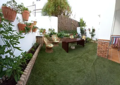 a garden with a table and chairs and plants at Relaxing Sanlúcar in Sanlúcar de Barrameda