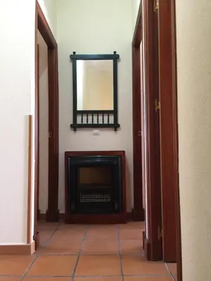 a hallway with a fireplace and a mirror on the wall at Relaxing Sanlúcar in Sanlúcar de Barrameda