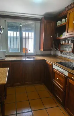 a kitchen with wooden cabinets and a sink at Relaxing Sanlúcar in Sanlúcar de Barrameda