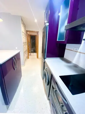 a kitchen with purple cabinets and a hallway at El rinconcito de la Isla in San Fernando