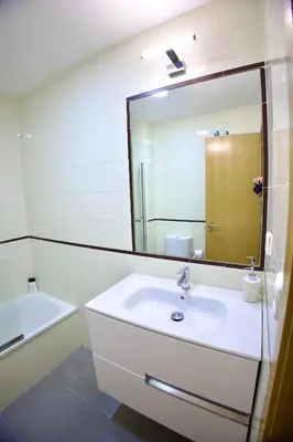 a white bathroom with a sink and a mirror at El rinconcito de la Isla in San Fernando