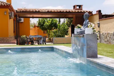 a swimming pool with a fountain in a yard at Villa Zahara de 3 habitaciones con Piscina in Cádiz