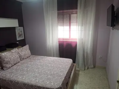 a bedroom with a bed in front of a window at Piso en la Costilla-Rota in Rota