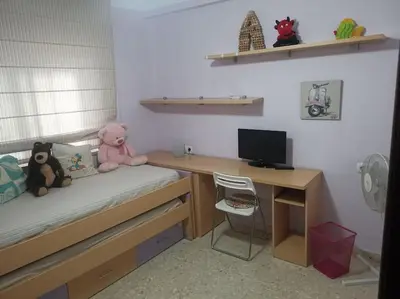 a bedroom with a desk and a bed with two stuffed animals at Piso en la Costilla-Rota in Rota