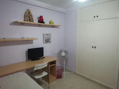 a room with a desk with a computer and a fan at Piso en la Costilla-Rota in Rota