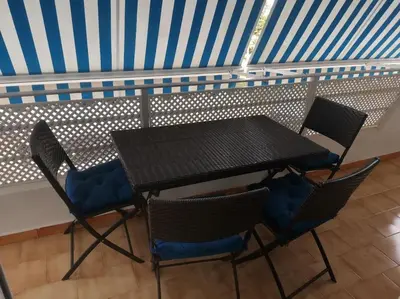 a table and chairs on a balcony with a blue ceiling at Piso en la Costilla-Rota in Rota