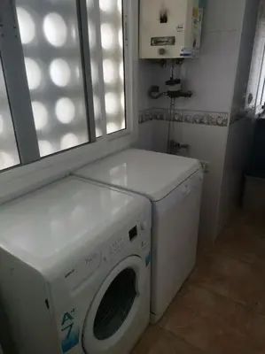 a laundry room with a washing machine and a window at Piso en la Costilla-Rota in Rota