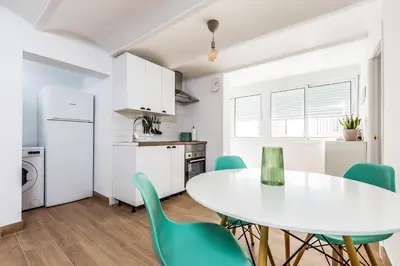 a kitchen and dining room with a white table and chairs at Apartamento en CENTRO CIUDAD in El Puerto de Santa María