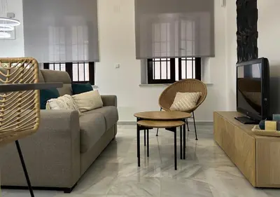 a living room with a couch and a tv at Apartamento Centro Cabildo Antiguo Convento in Sanlúcar de Barrameda