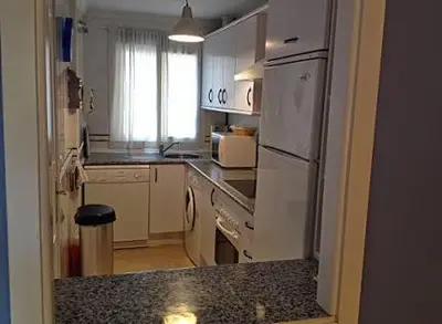 a kitchen with a white refrigerator and a counter top at BAJO EN COSTA GADIR in Chiclana de la Frontera