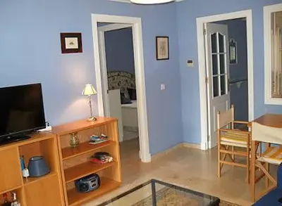 a living room with a flat screen tv and a table at BAJO EN COSTA GADIR in Chiclana de la Frontera