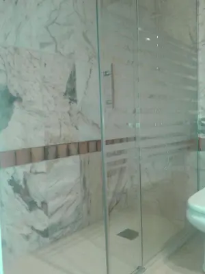 a bathroom with a glass shower with a toilet at BAJO EN COSTA GADIR in Chiclana de la Frontera