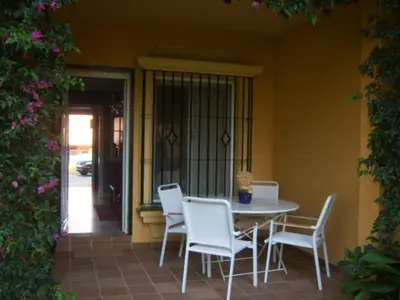 a table and chairs sitting on a porch with a table and chairsktop at BAJO EN COSTA GADIR in Chiclana de la Frontera