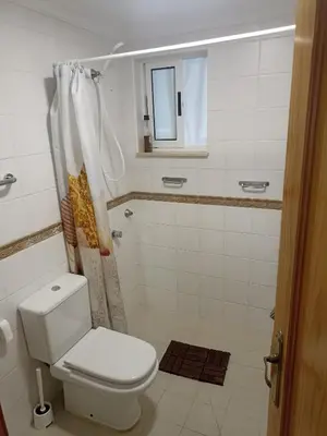 a bathroom with a toilet and a shower and a mirror at Apartamento Bajo en Valdelagrana, Primera Línea de Playa in El Puerto de Santa María