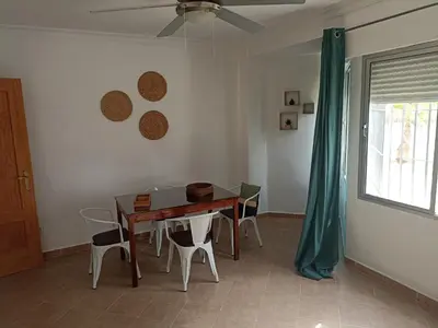 a dining room table with chairs and a ceiling fan at Apartamento Bajo en Valdelagrana, Primera Línea de Playa in El Puerto de Santa María