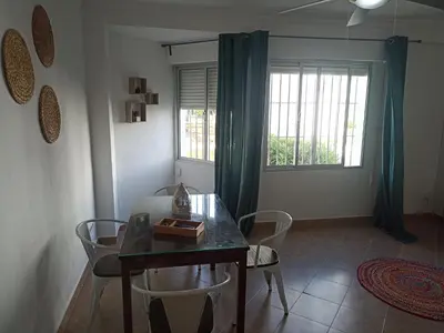 a living room with a dining room table and chairs at Apartamento Bajo en Valdelagrana, Primera Línea de Playa in El Puerto de Santa María