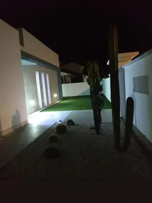 a dark room with a building and a vase with a plant at CHALET ARRILUCE Plaza de parking gratis en la playa in Chiclana de la Frontera