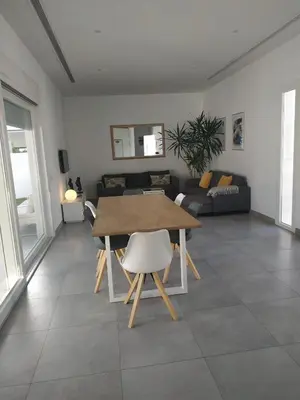 a living room with a table and a couch at CHALET ARRILUCE Plaza de parking gratis en la playa in Chiclana de la Frontera