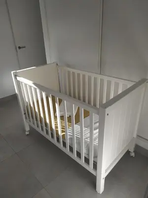 a white crib sitting in a room at CHALET ARRILUCE Plaza de parking gratis en la playa in Chiclana de la Frontera