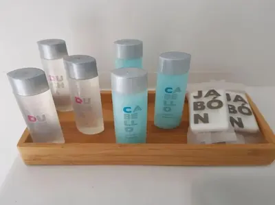 a wooden shelf with four bottles of sunscreen on it at CHALET ARRILUCE Plaza de parking gratis en la playa in Chiclana de la Frontera