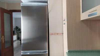 a stainless steel refrigerator in the corner of a kitchen at Sherryflat Claveles - Parking in Jerez de la Frontera