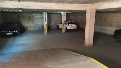 a parking garage with two cars parked in it at Sherryflat Claveles - Parking in Jerez de la Frontera