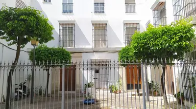 a white building with trees in front of it at Sherryflat Claveles - Parking in Jerez de la Frontera